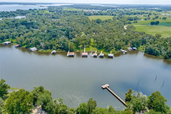 an aerial view of a house with a yard and lake view