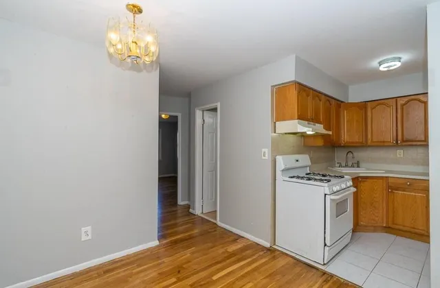 a kitchen with a stove a refrigerator cabinets and wooden floor