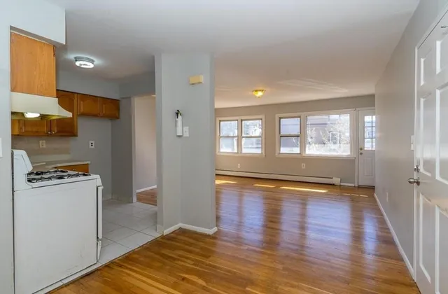 a view of a kitchen with wooden floor and electronic appliances