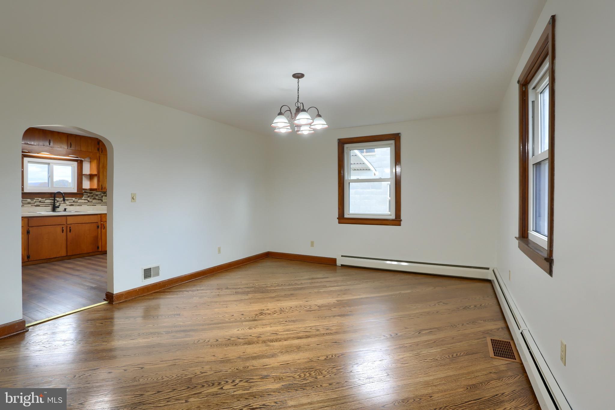 338 Locust Street Halifax, PA 17032 - Photo 8 of 43 an empty room with wooden floor chandelier and windows