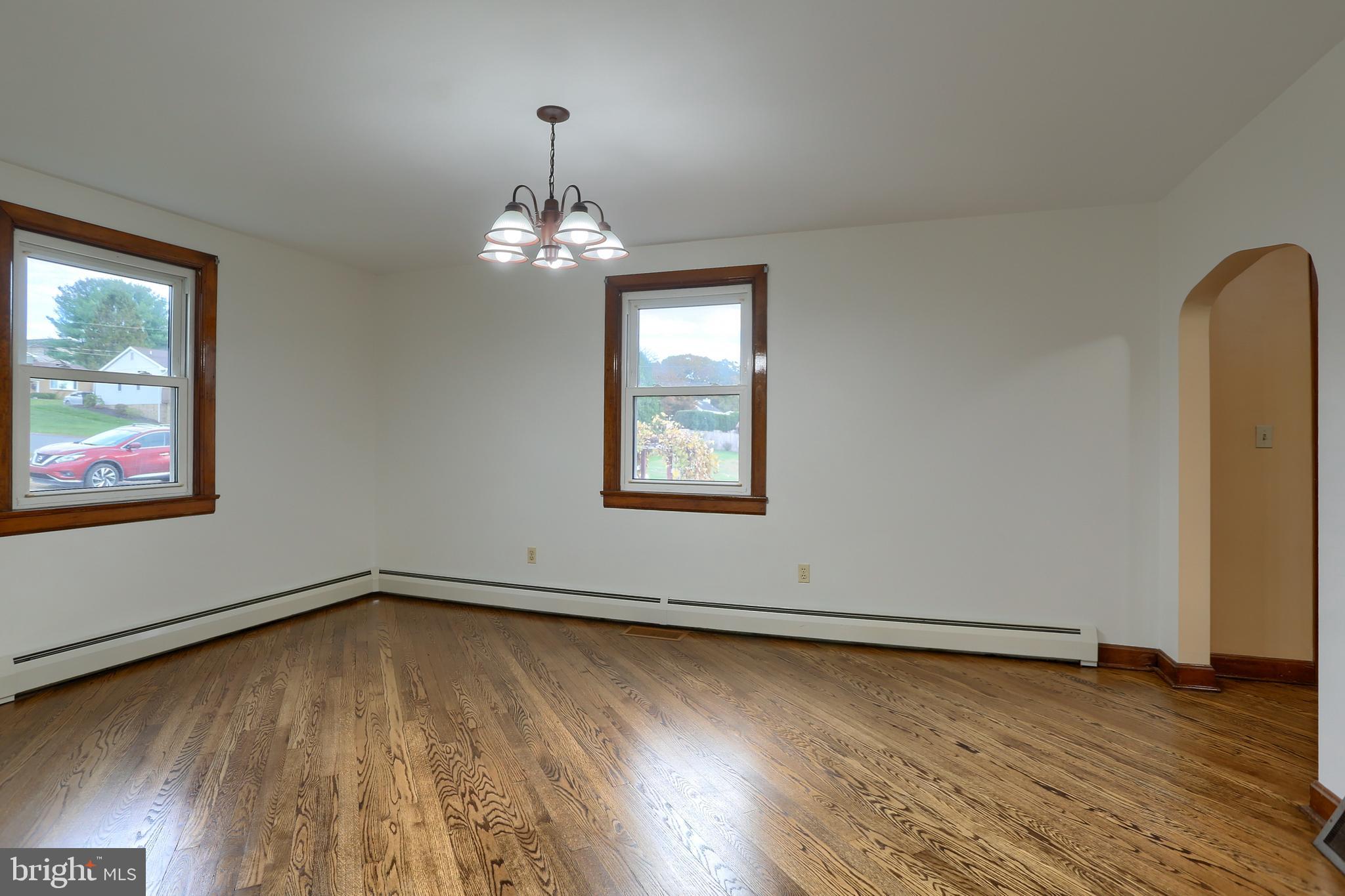 338 Locust Street Halifax, PA 17032 - Photo 9 of 43 an empty room with wooden floor chandelier and windows