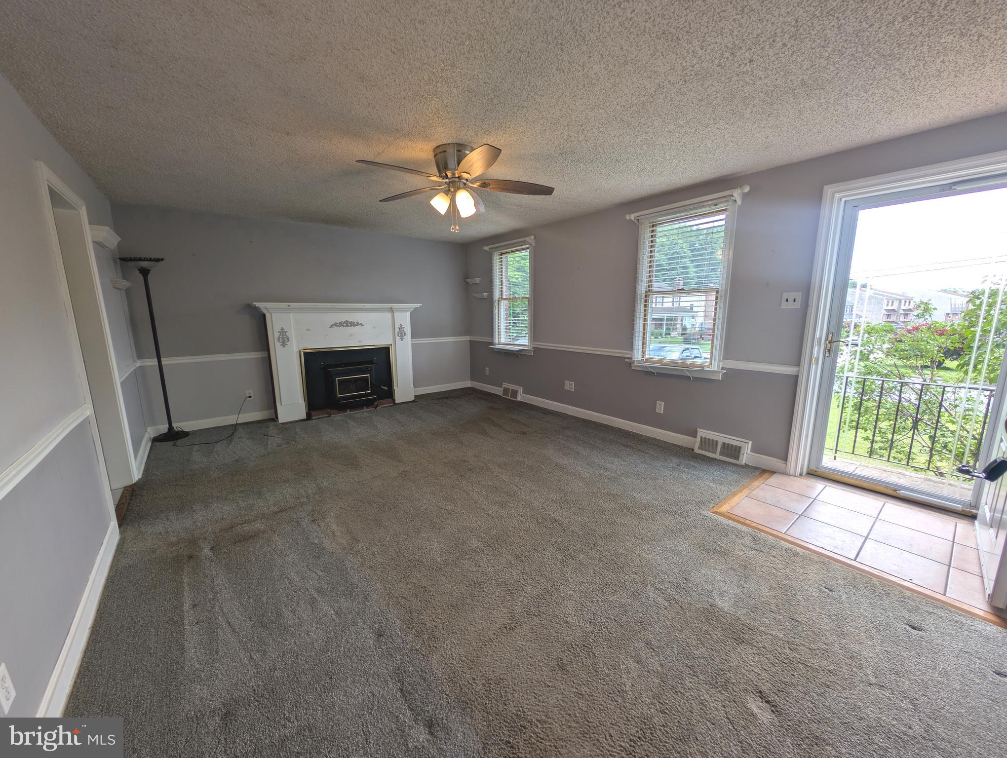 1129 Providence Road Springfield, PA 19064 - Photo 2 of 15 an empty room with windows fireplace and fan