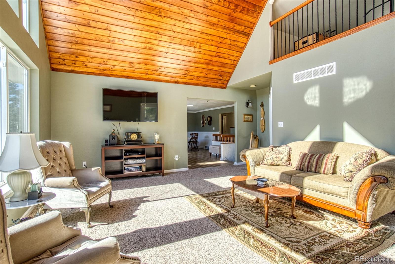 25681 Mosier Circle Conifer, CO 80433 - Photo 13 of 29 a living room with furniture a flat screen tv and a large window