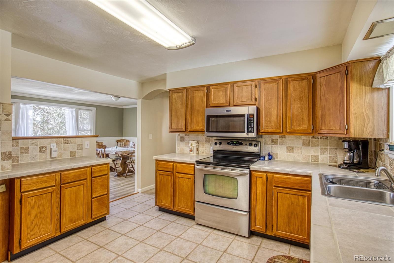 25681 Mosier Circle Conifer, CO 80433 - Photo 17 of 29 a kitchen with a sink appliances and cabinets