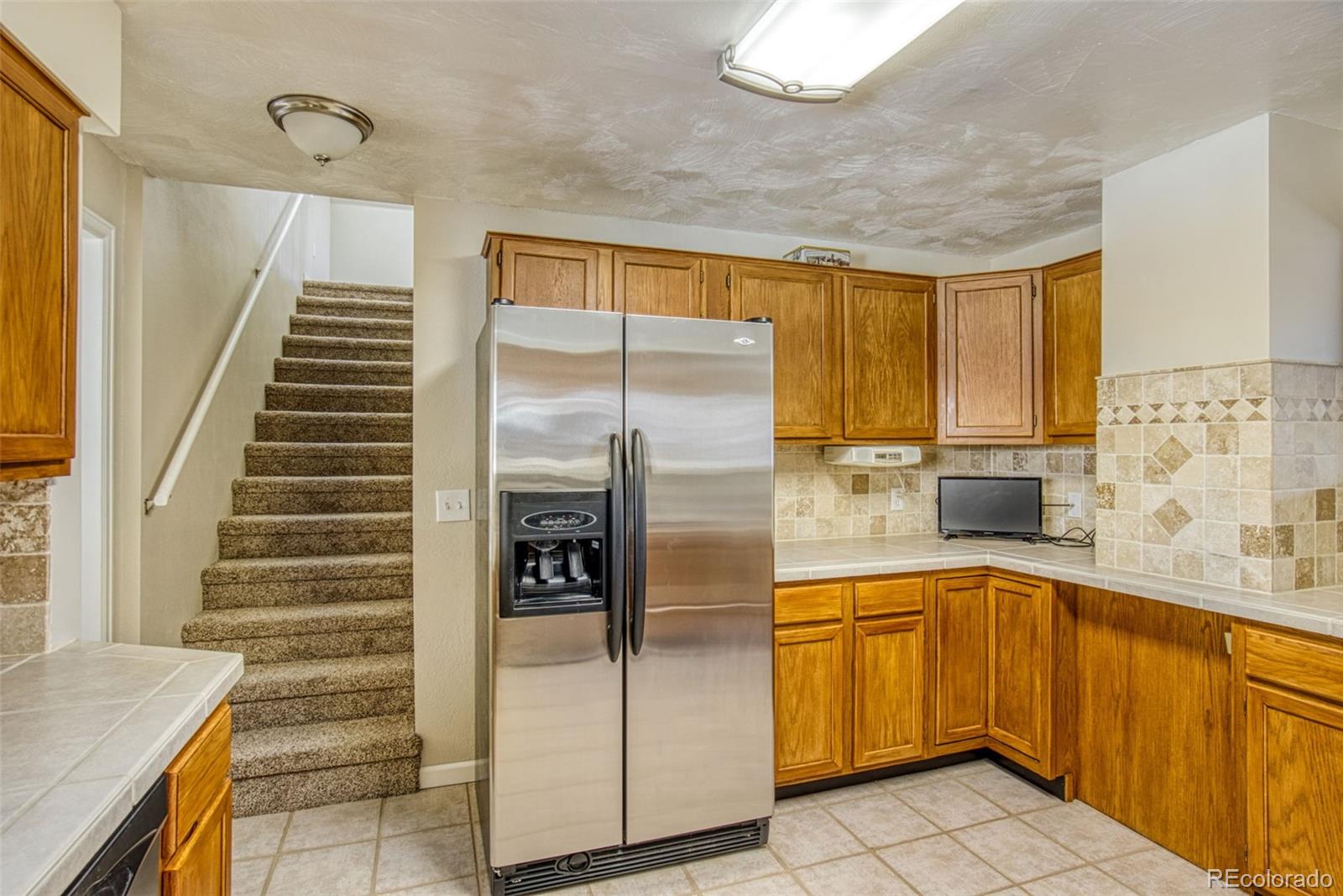 25681 Mosier Circle Conifer, CO 80433 - Photo 18 of 29 a kitchen with a refrigerator and sink