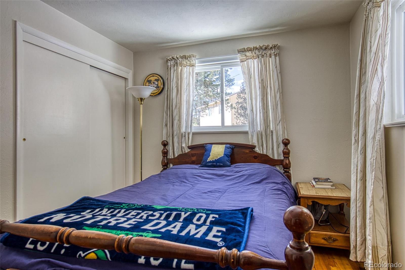 25681 Mosier Circle Conifer, CO 80433 - Photo 19 of 29 a bed sitting in a bedroom next to a window
