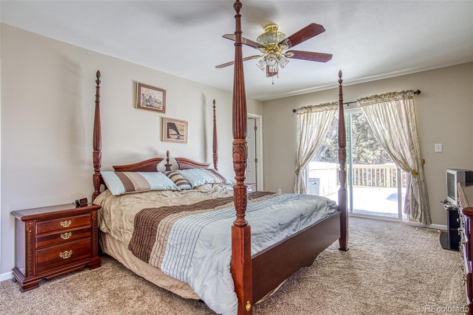 25681 Mosier Circle Conifer, CO 80433 - Photo 22 of 29 a bedroom with a bed and a chandelier