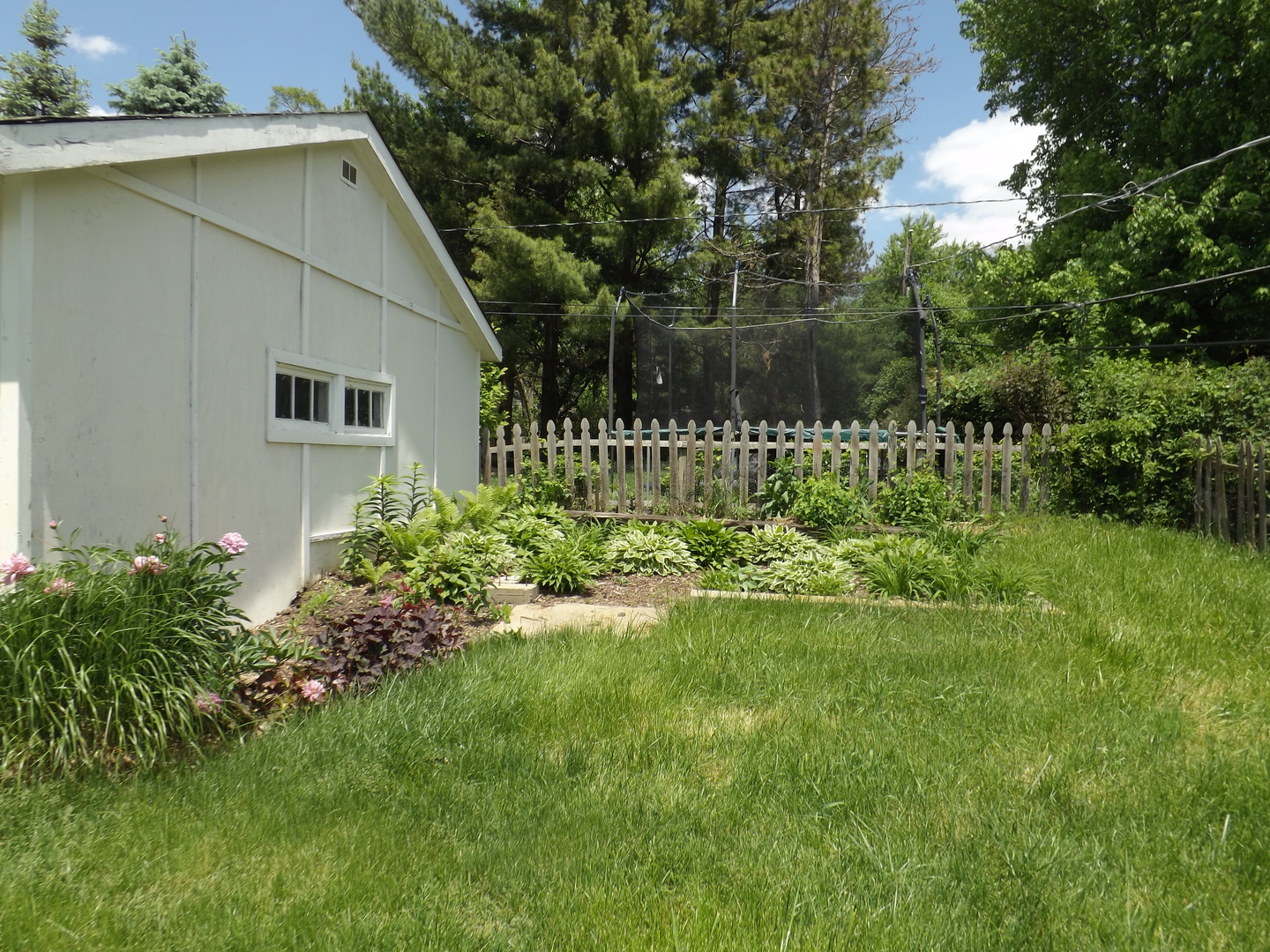 15 Hickory Road Cary, IL 60013 - Photo 17 of 19 a backyard of a house with a garden and plants