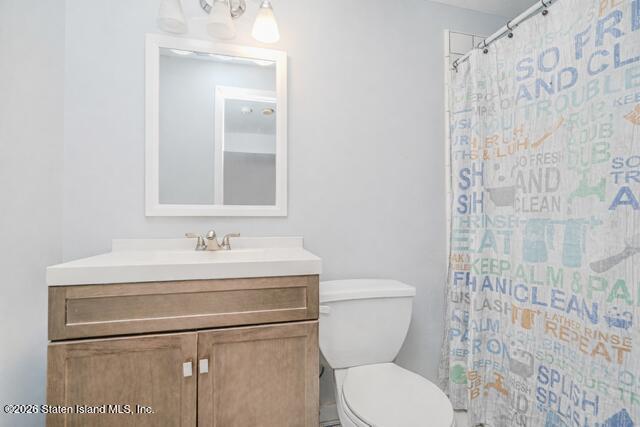 101 Beach Street Staten Island, NY 10304 - Photo 14 of 20 a bathroom with a toilet sink vanity and shower