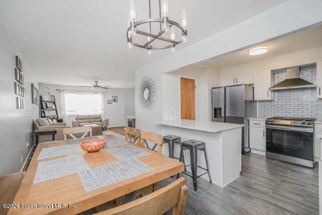 101 Beach Street Staten Island, NY 10304 - Photo 5 of 20 a open kitchen with stainless steel appliances granite countertop a stove refrigerator and a fireplace with wooden floor