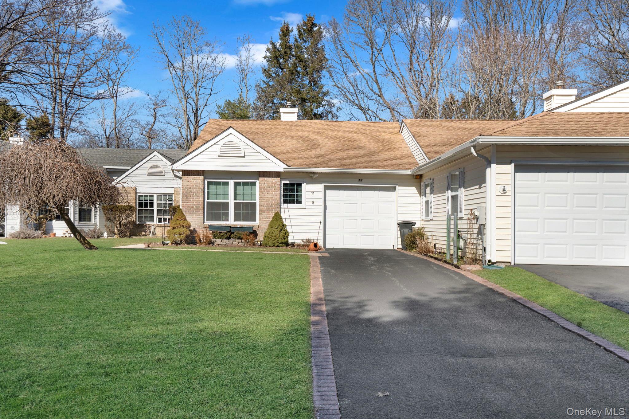 a front view of a house with a garden and yard