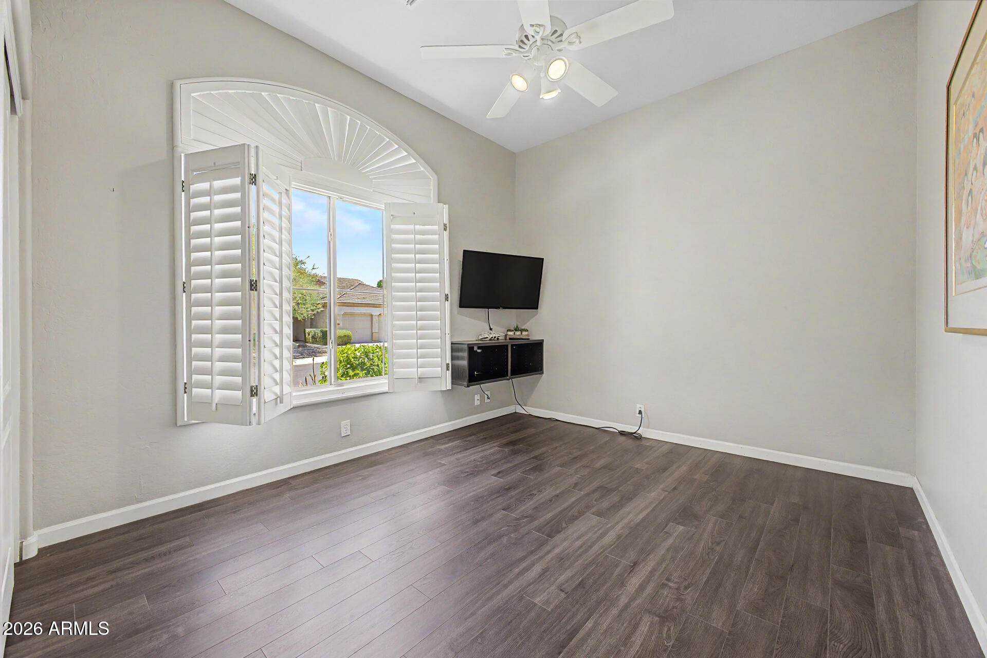 1632 West Frye Road Phoenix, AZ 85045 - Photo 20 of 37 an empty room with wooden floor fan and windows