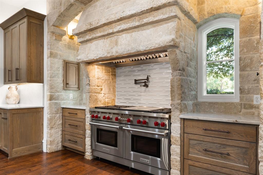 6413 Old Gate Road Plano, TX 75024 - Photo 11 of 38 a kitchen with stainless steel appliances wooden floor sink and wooden cabinets