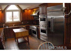 2170 Rock Road Rutherfordton, NC 28139 - Photo 15 of 17 a kitchen with stainless steel appliances kitchen island granite countertop a refrigerator a stove and a sink with wooden floor