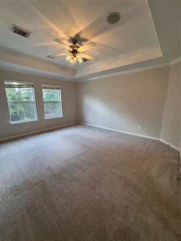 en empty room with windows and chandelier fan