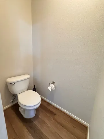a white toilet sitting next to a white wall