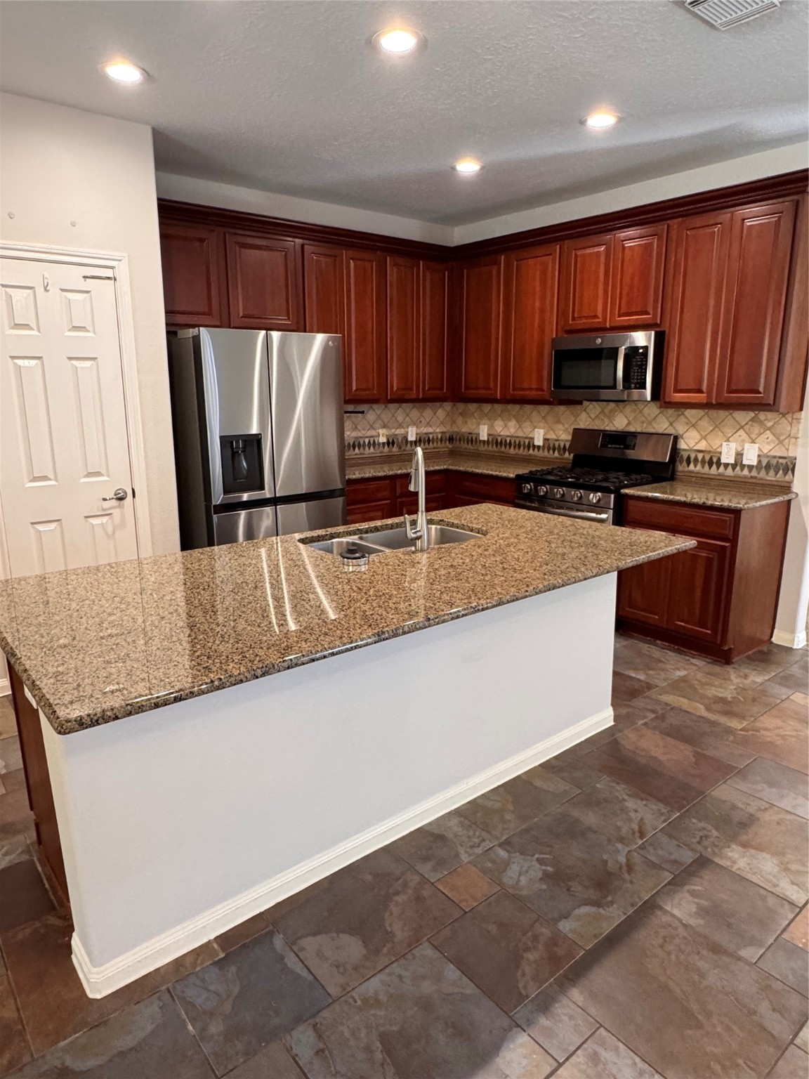 137 East Montfair Boulevard Spring, TX 77382 - Photo 5 of 23 a kitchen with stainless steel appliances granite countertop a stove top oven a refrigerator a sink and dishwasher
