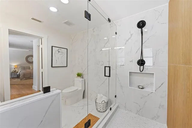 a bathroom with a tub a window and glass door shower