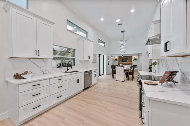 a large kitchen with stainless steel appliances lots of counter space and view living room