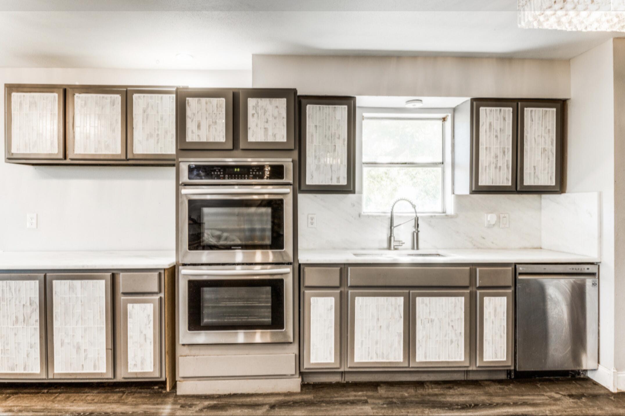 610 Pleasant Grove Road Elgin, TX 78621 - Photo 11 of 25 Kitchen featuring stainless steel appliances, light countertops, decorative backsplash, and dark wood finished floors