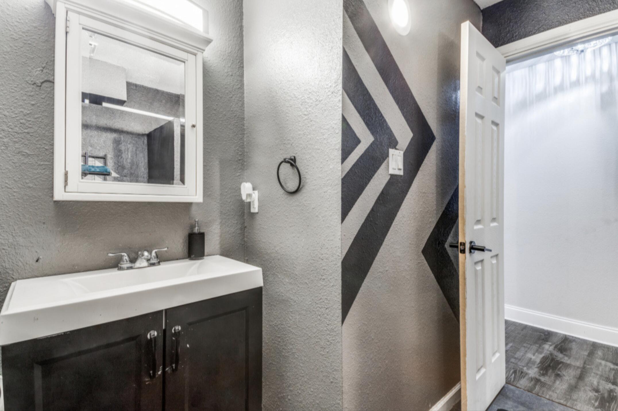 610 Pleasant Grove Road Elgin, TX 78621 - Photo 24 of 25 Bathroom with a textured wall, vanity, and dark wood-style flooring
