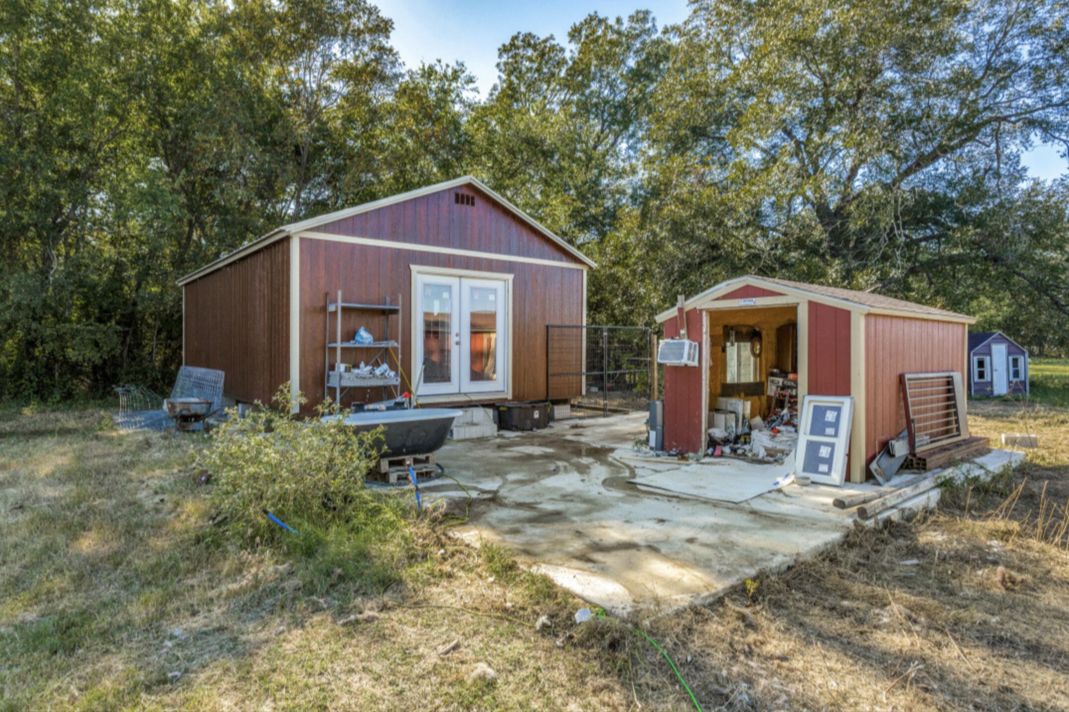 610 Pleasant Grove Road Elgin, TX 78621 - Photo 25 of 25 View of shed with french doors and view of wooded area