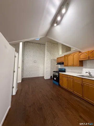 a kitchen with stainless steel appliances wooden cabinets and a wooden floor