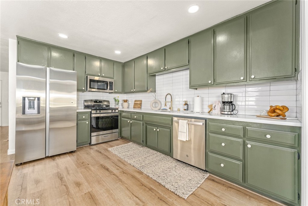 57508 Buena Suerte Road Yucca Valley, CA 92284 - Photo 29 of 61 a kitchen with a refrigerator sink and wooden cabinets