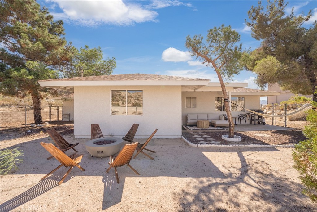 57508 Buena Suerte Road Yucca Valley, CA 92284 - Photo 57 of 61 a view of a patio with a dining table and chairs with wooden fence