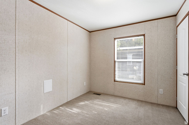 2875 North Hill Field Road, Unit 62 Layton, UT 84041 - Photo 23 of 34 Carpeted room featuring a single window with blinds, light-colored walls with vertical paneling, and contrasting dark wood trim