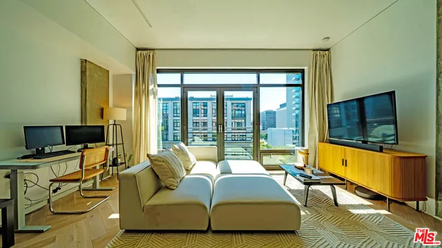 a living room with furniture and a flat screen tv next to a large window