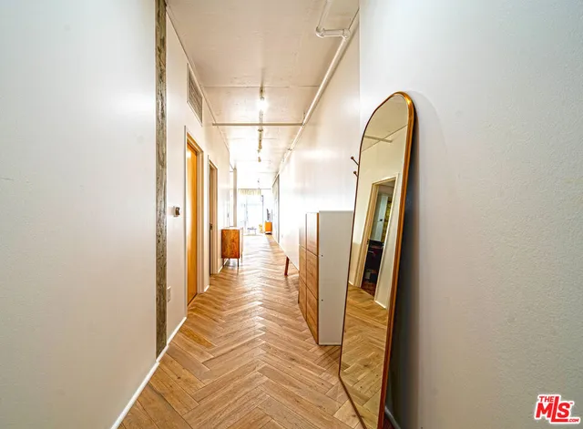 a view of a hallway with wooden floor