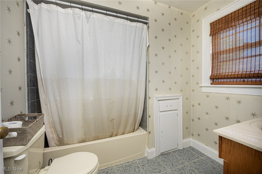540 Cambridge Road Coshocton, OH 43812 - Photo 24 of 38 Bathroom featuring wallpapered walls, shower / tub combo with curtain, vanity, and light tile patterned floors