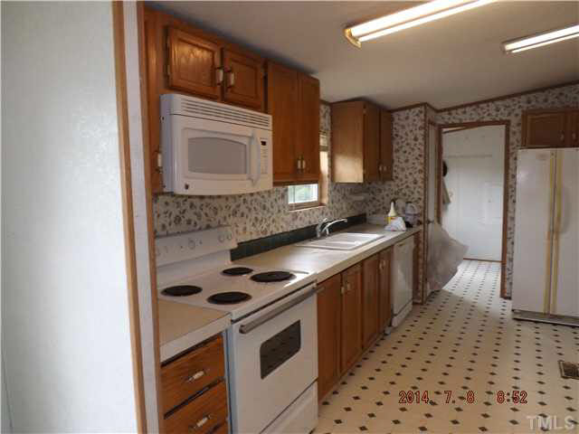 1199 Browns Crossroads Road Staley, NC 27355 - Photo 3 of 10 a kitchen with granite countertop a stove sink and cabinets