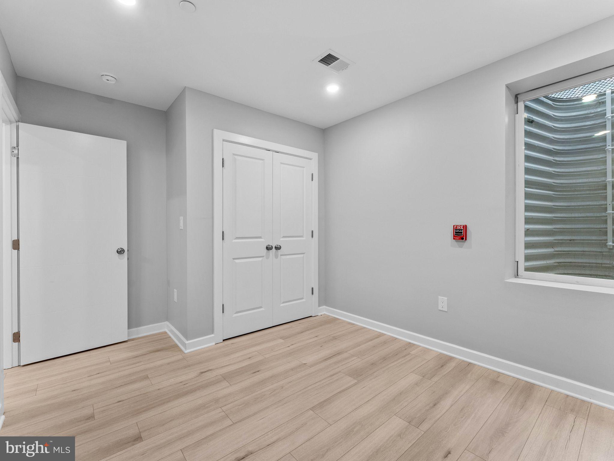1682 North 54th Street, Unit 2 Philadelphia, PA 19131 - Photo 12 of 15 a view of an empty room with wooden floor and a window