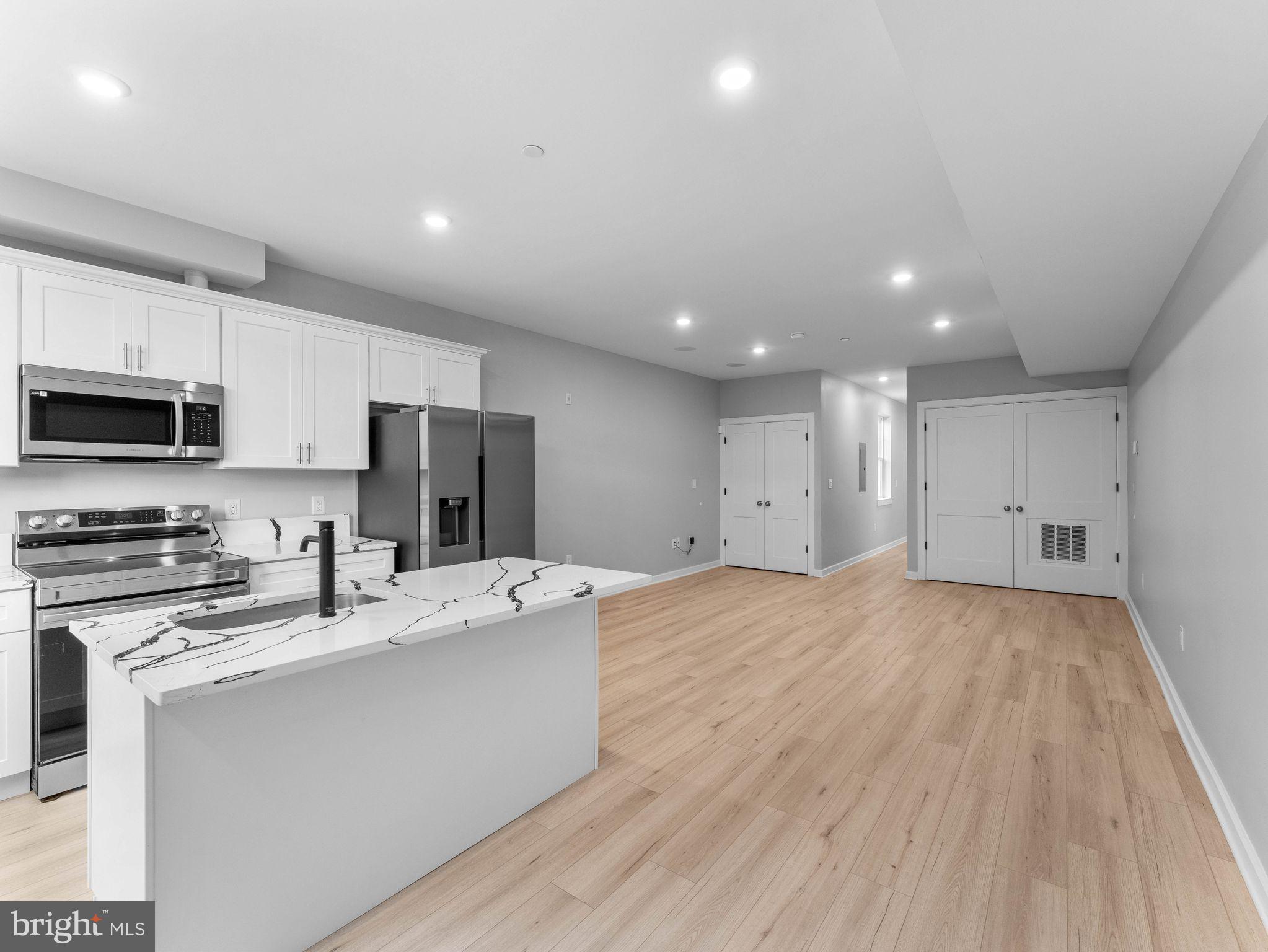 1682 North 54th Street, Unit 2 Philadelphia, PA 19131 - Photo 6 of 15 a kitchen with stainless steel appliances a refrigerator sink and microwave