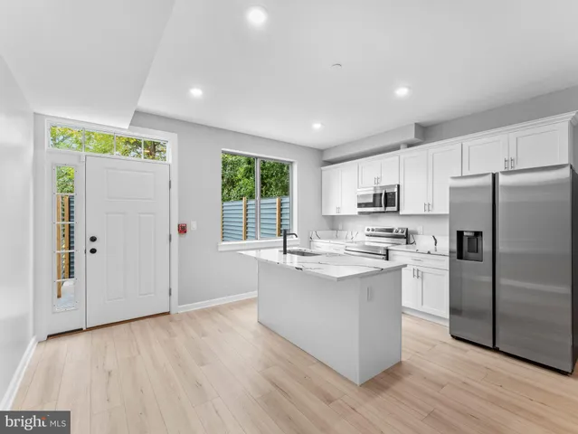 a kitchen with stainless steel appliances granite countertop a refrigerator and a stove top oven