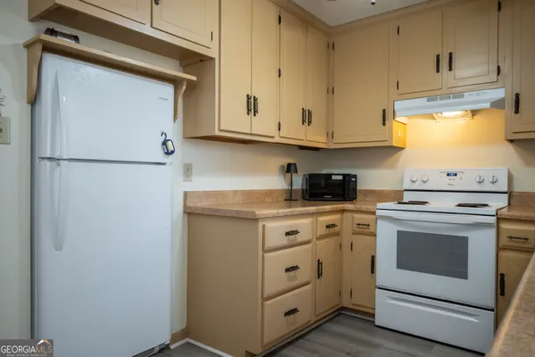 a kitchen with white cabinets and white appliances