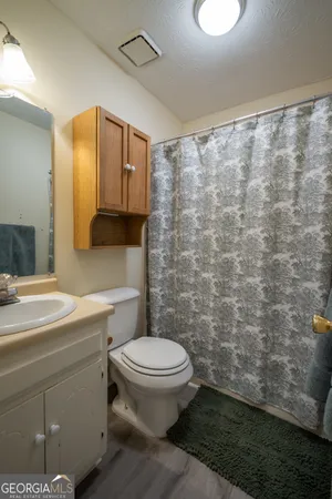 a bathroom with a sink a toilet and a mirror