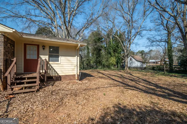 a view of a house with a yard and wooden fence