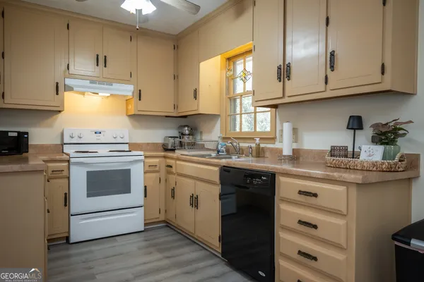 a kitchen with granite countertop white cabinets and white appliances