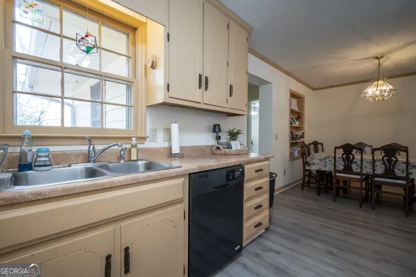 a kitchen with a sink cabinets and wooden floor