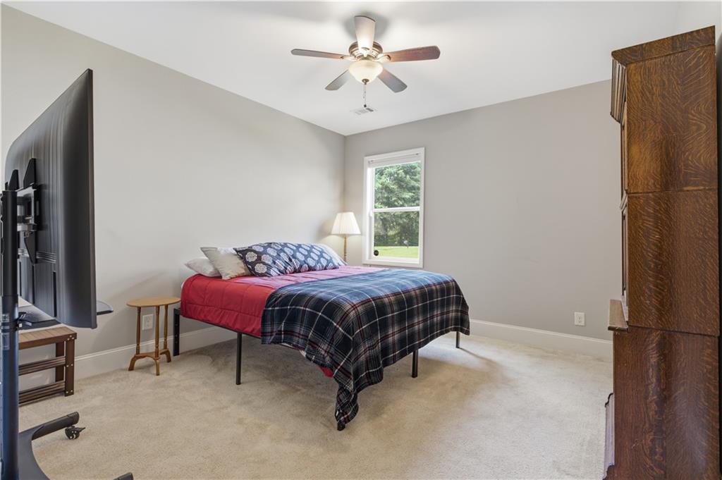 5825 Willow Oak Pass Cumming, GA 30040 - Photo 23 of 55 a bedroom with a bed a chandelier and a window