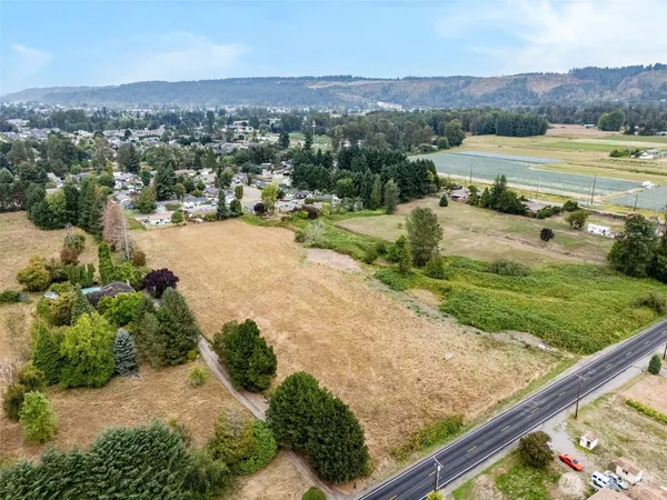 an aerial view of residential houses with outdoor space and trees