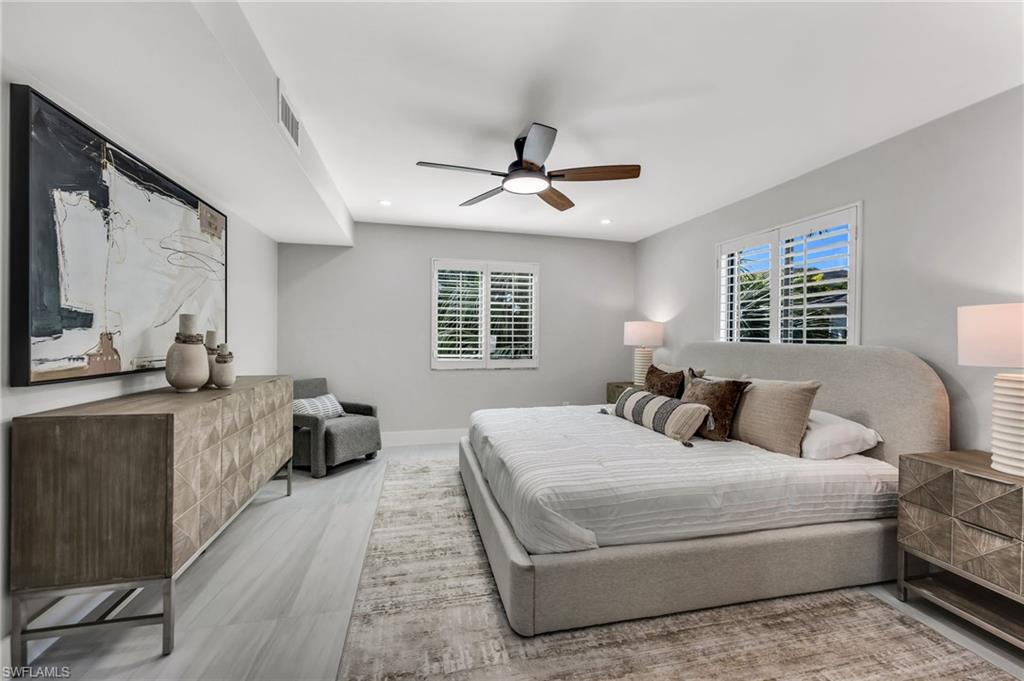 990 8th Street South, Unit 1C Naples, FL 34102 - Photo 13 of 24 a bedroom with a large bed couch and a window