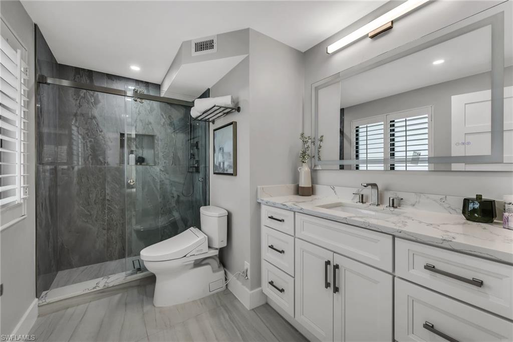 990 8th Street South, Unit 1C Naples, FL 34102 - Photo 16 of 24 a spacious bathroom with a toilet sink and shower