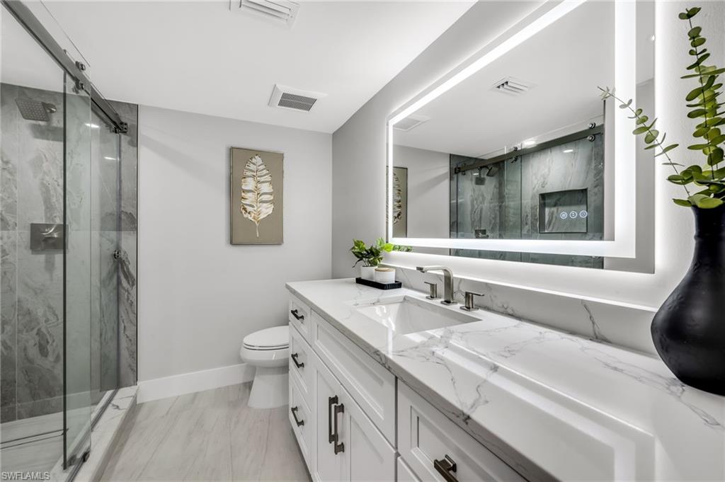 990 8th Street South, Unit 1C Naples, FL 34102 - Photo 19 of 24 a bathroom with a sink a toilet and shower