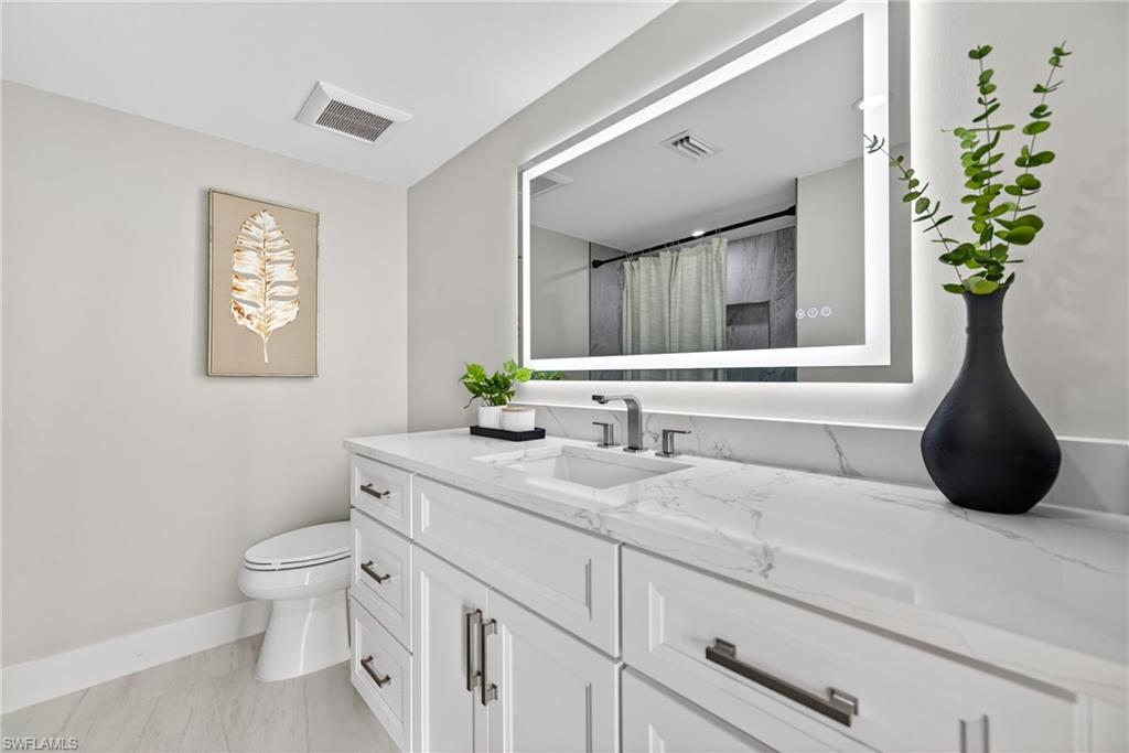 990 8th Street South, Unit 1C Naples, FL 34102 - Photo 20 of 24 a bathroom with a sink a toilet and a mirror