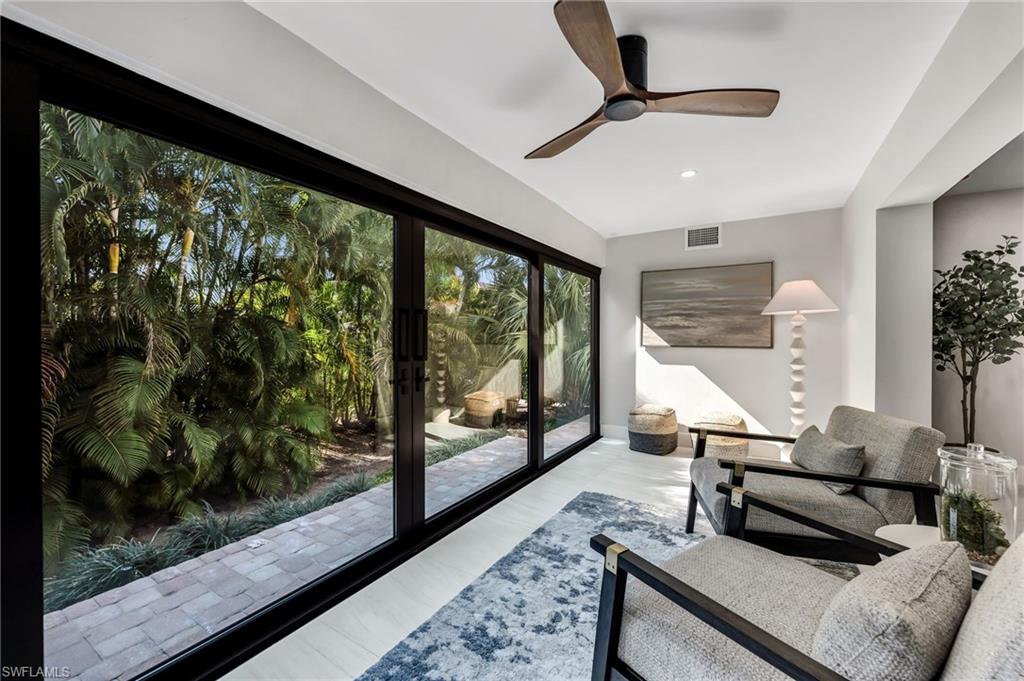990 8th Street South, Unit 1C Naples, FL 34102 - Photo 7 of 24 a living room with furniture and a floor to ceiling window