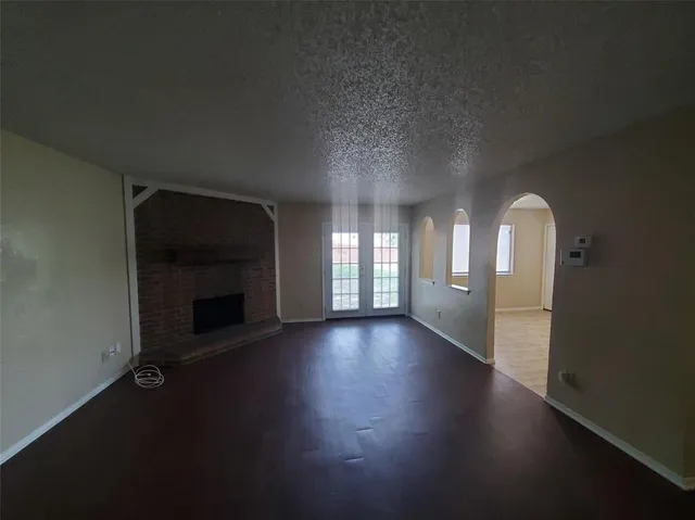 a view of a livingroom with wooden floor and a fireplace
